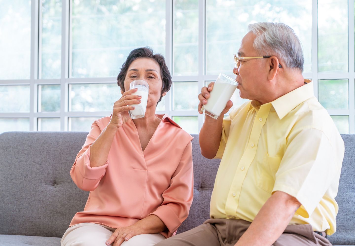 Two,senior,couple,is,drinking,milk,while,relaxing,on,a